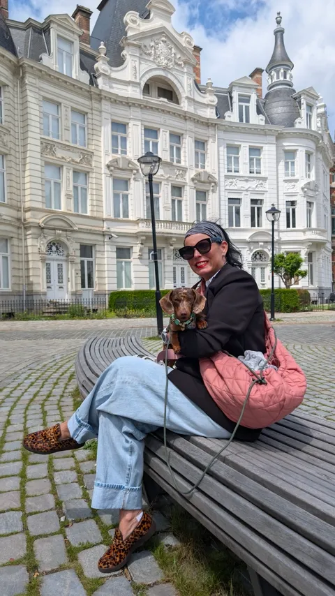 Celine op schoot op een bank, met de roze draagtas naast haar