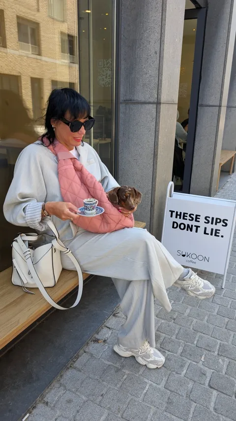 Celine in haar roze draagtas van Bob & Scottie bij een kopje koffie voor Sukoon Coffee