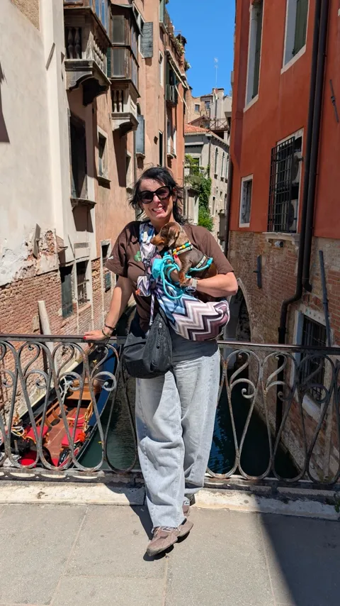 Celine in de draagtas op een brug boven een gracht in Venetië