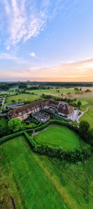 Luchtbeeld van een hotelterrein in een groene omgeving
