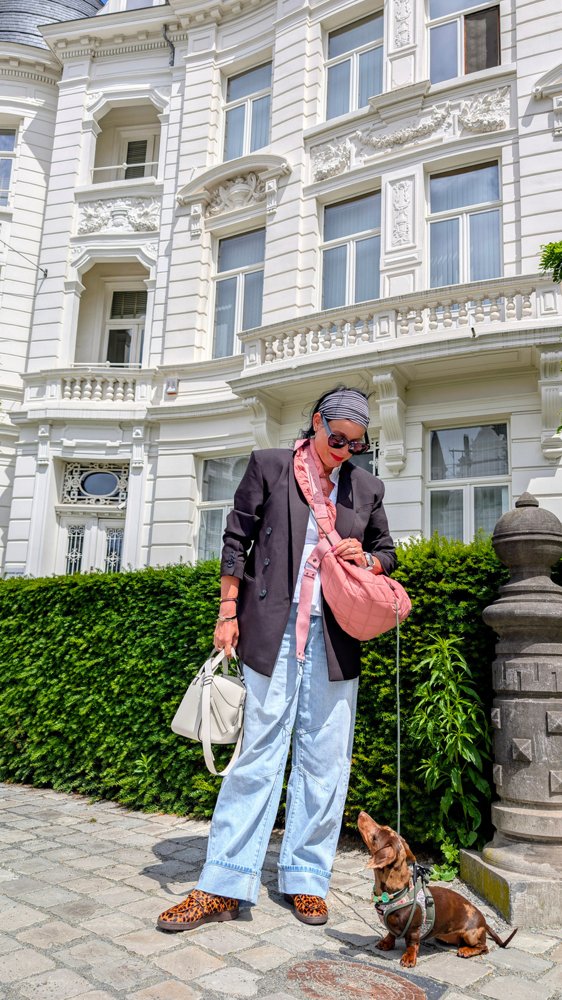 Celine en haar baasje bij een stijlvolle hotelingang