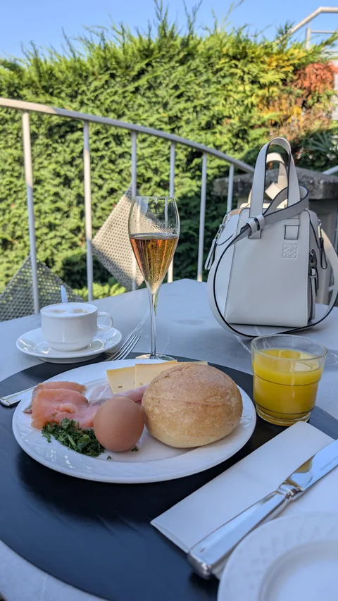 Ontbijt, koffie en een glas op een zonnige terrastafel